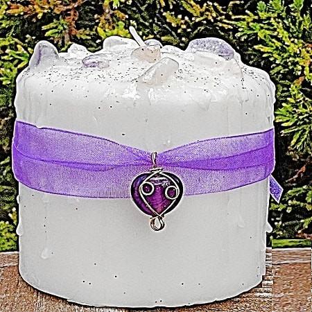 Goddess Gift Set 6 Goddess Gift Set, white candle wrapped with a purple ribbon and a silver Goddess charm, set outdoors with greenery in the background.